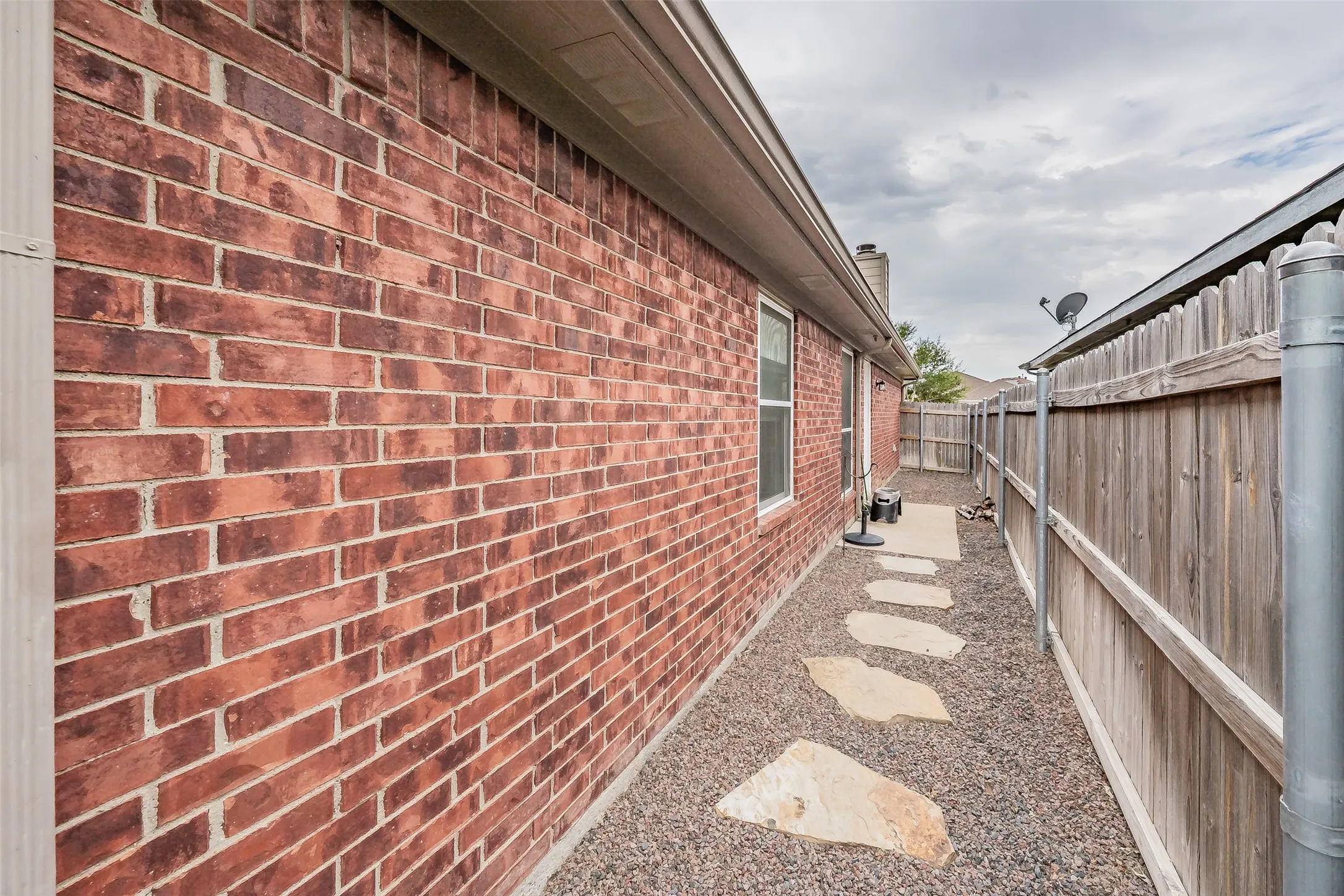 Red brick exterior with white window trim and a seamless gutter system