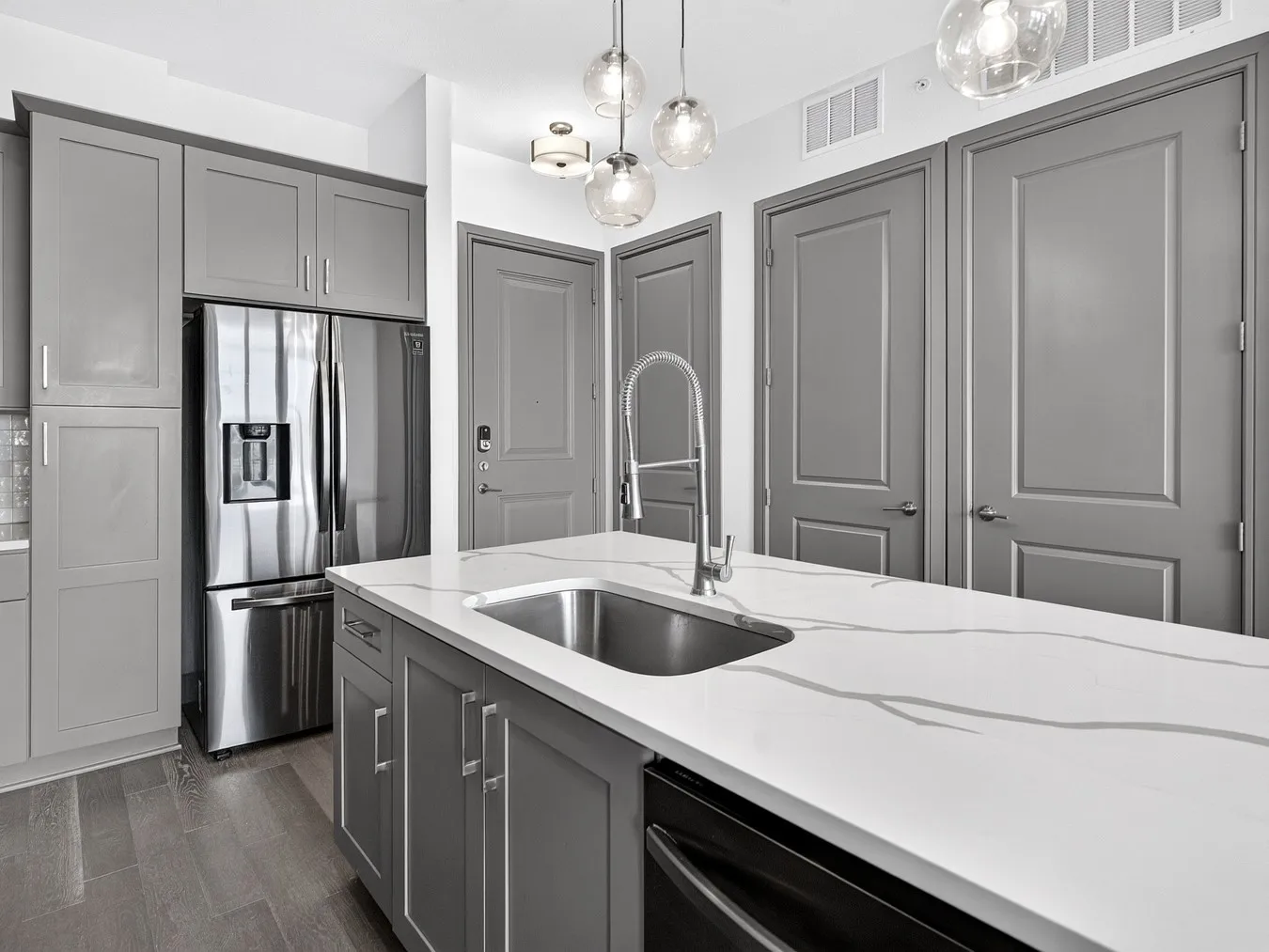 Kitchen island with an undermount sink, gooseneck faucet, and veined countertop