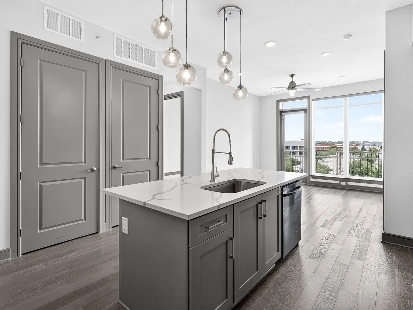 Kitchen island featuring a single-basin sink, gooseneck faucet, and integrated dishwasher