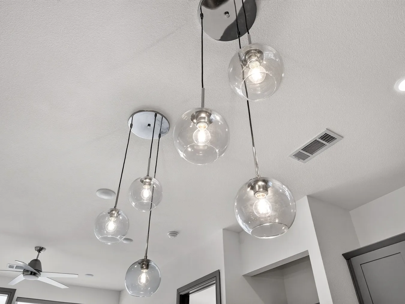 Multi-bulb pendant lighting fixtures with clear globes