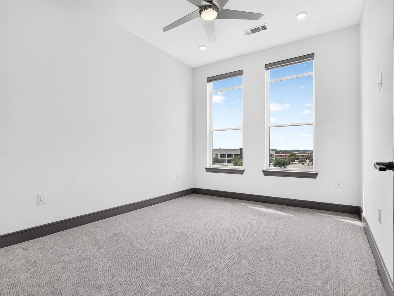 Recessed lighting, ceiling fan, and light gray carpeting