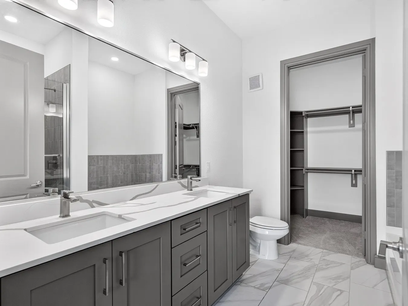 Dual vanity with undermount sinks, quartz countertops, and brushed nickel fixtures