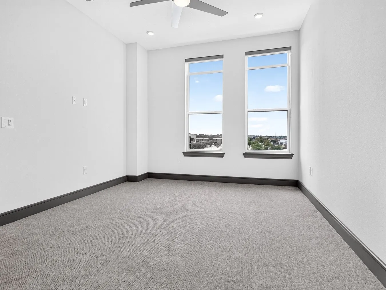 Recessed lighting, ceiling fan, and light gray carpeting