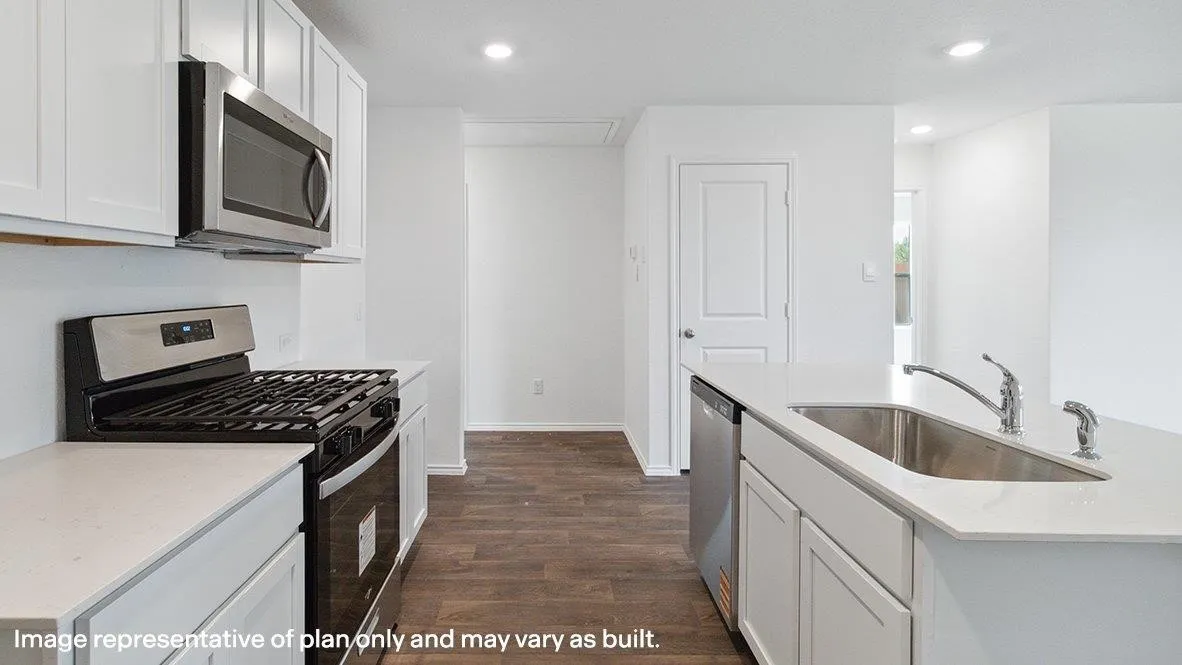 Stainless steel microwave, gas range, and dishwasher complement white cabinetry