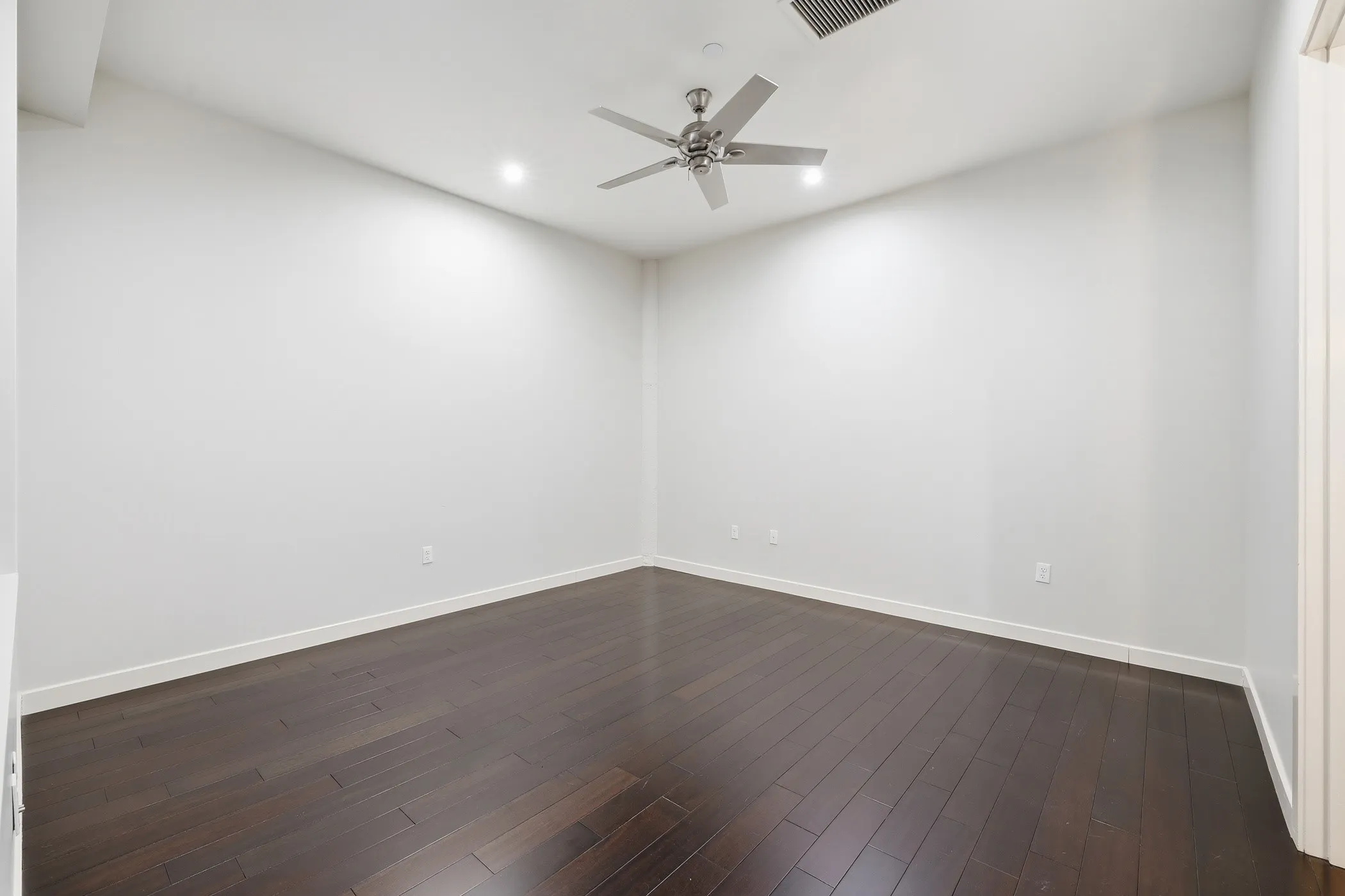 Spare room featuring dark wood-type flooring, recessed lighting, and ceiling fan