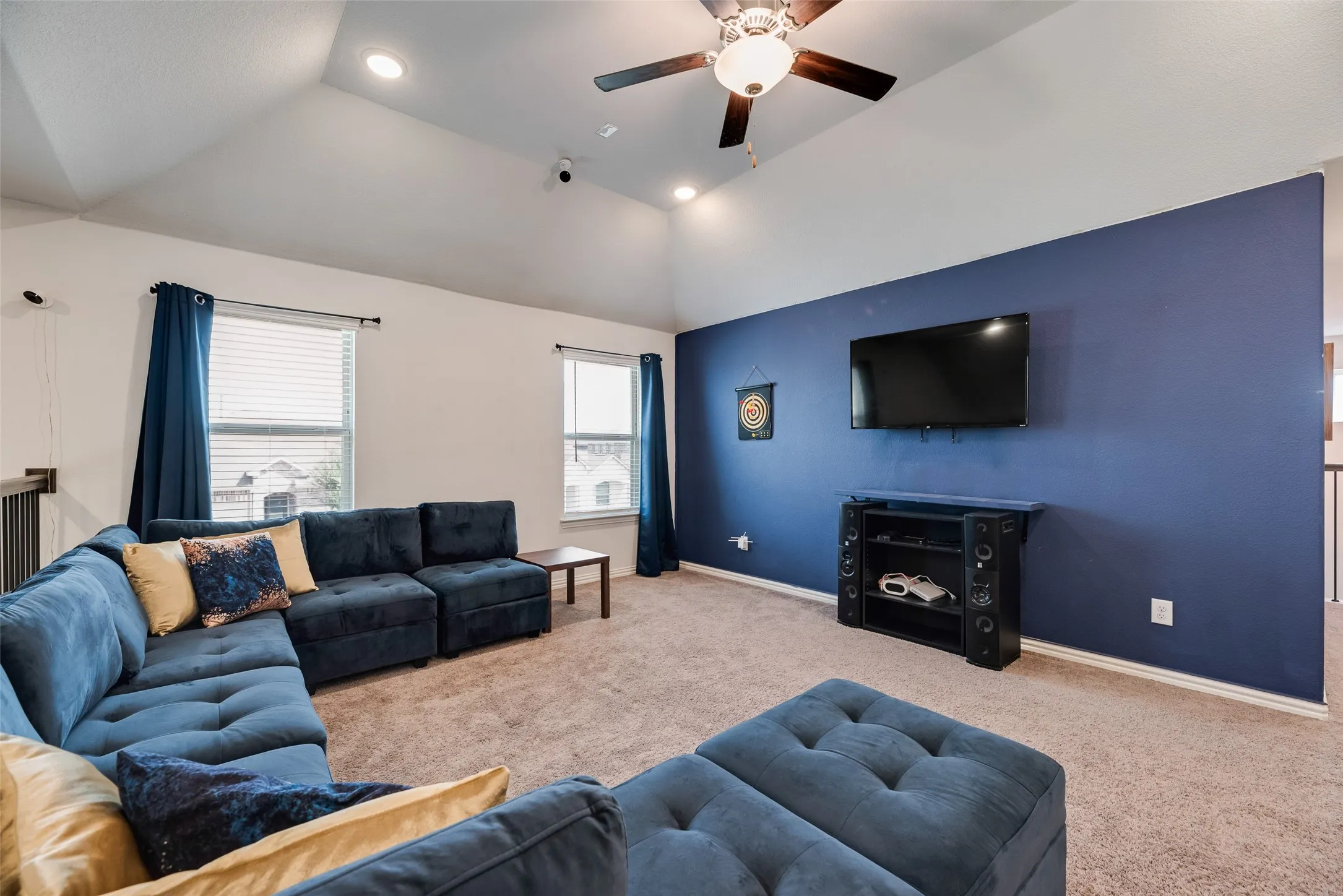 The upstairs living room features a Vaulted ceiling with recessed lighting and a ceiling fan.