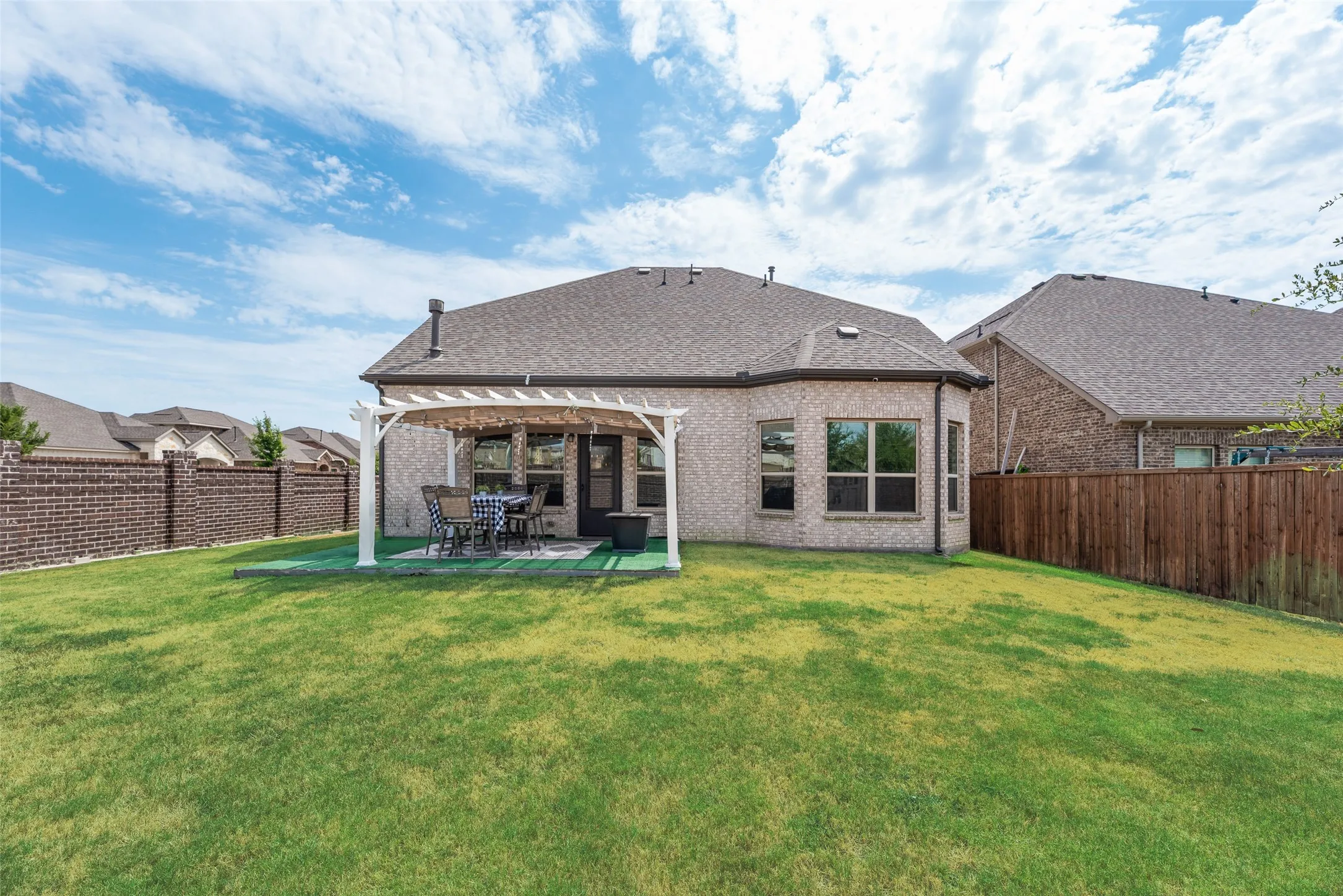 Expansive backyard with a manicured lawn, an outdoor patio, and a shed!