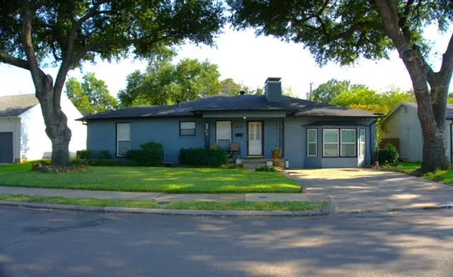 Single-story residence with a gray exterior finish, a black shingle roof, and a prominent bay window