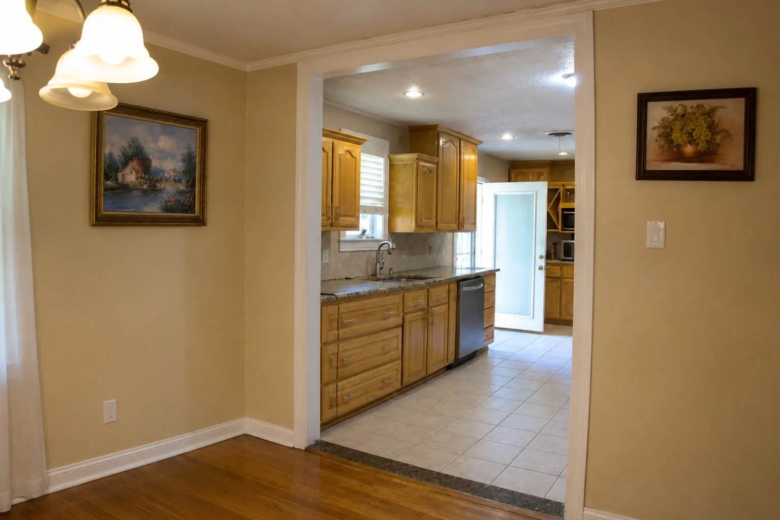 Hardwood flooring, cased opening, wood cabinetry, stone countertops, stainless steel dishwasher