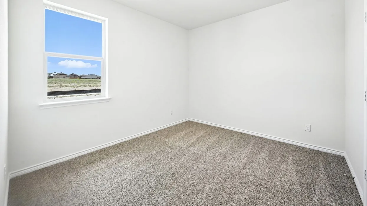 Neutral wall paint, window with exterior scenery, and carpet flooring