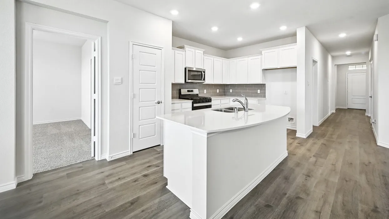 Kitchen featuring white cabinetry, stainless steel appliances, a white island with an undermount sink, recessed lighting, and wood-finish flooring