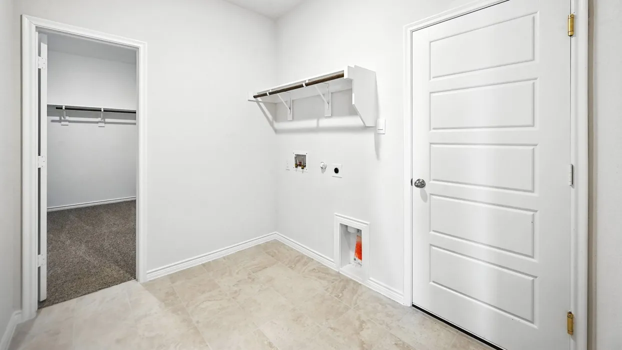 Versatile utility room with polished concrete flooring, white painted walls, and abundant storage solutions including wall-mounted shelving and cabinetry