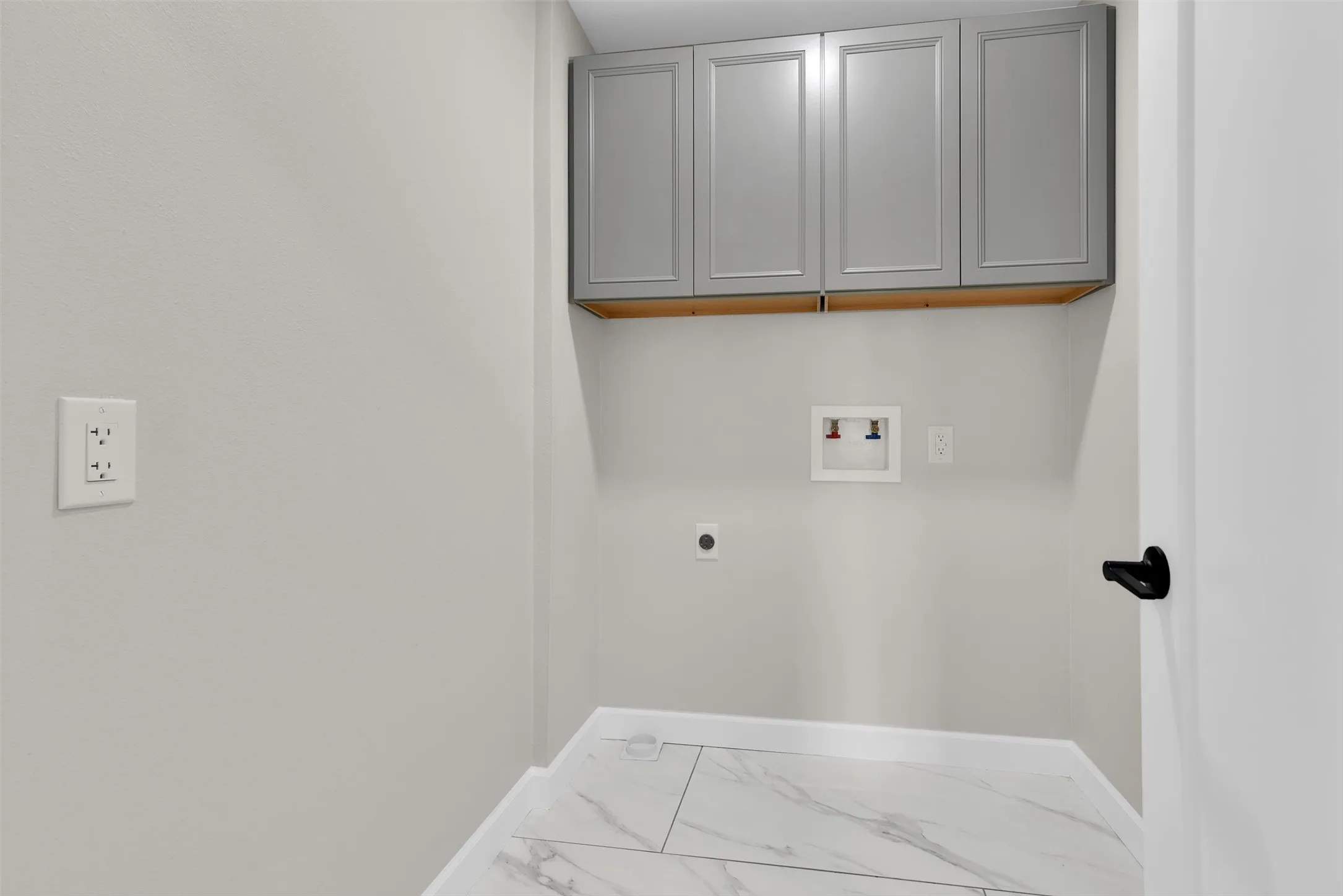 White walls with light gray upper cabinetry and white baseboards