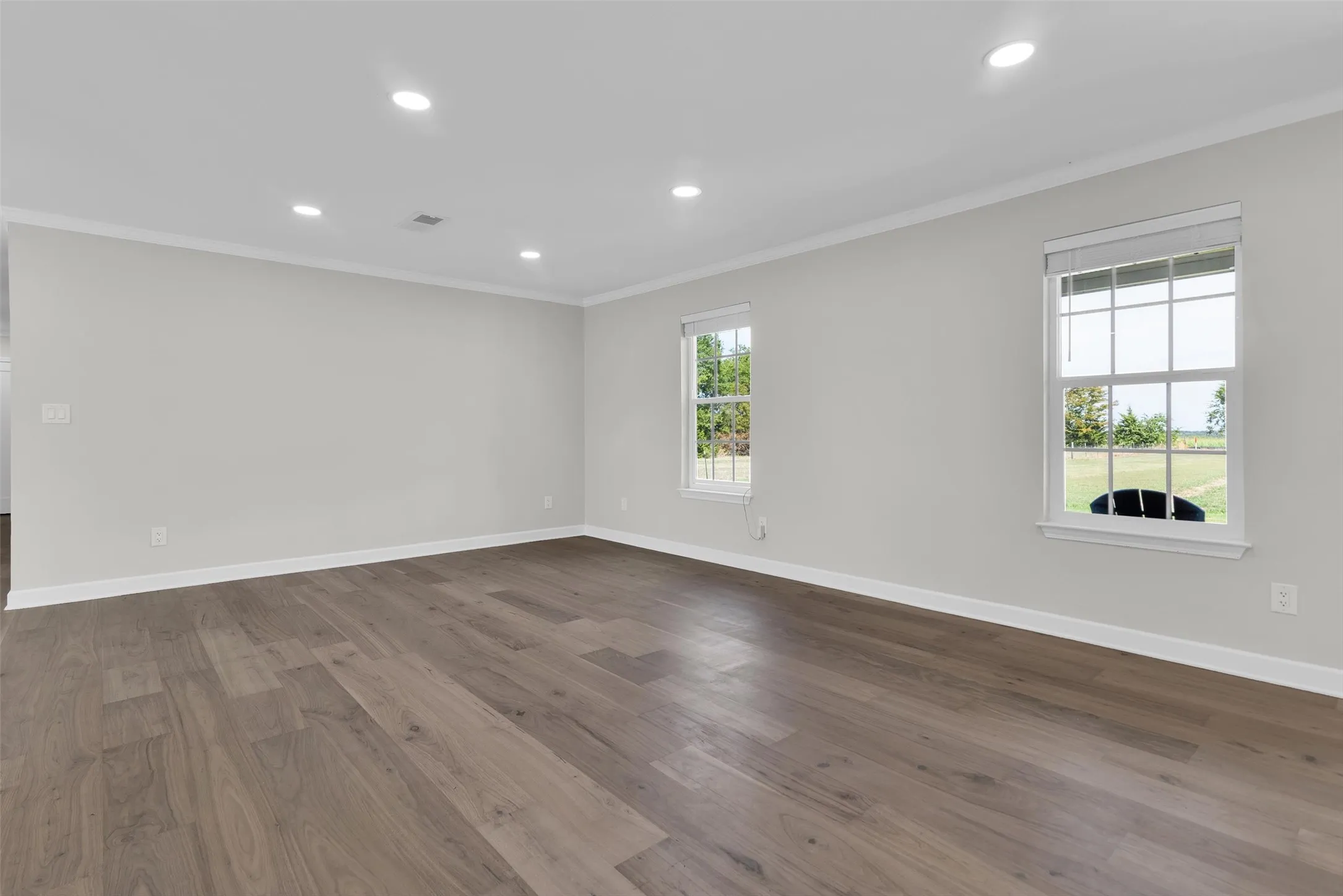 Wood-finish flooring, recessed lighting, and crown molding