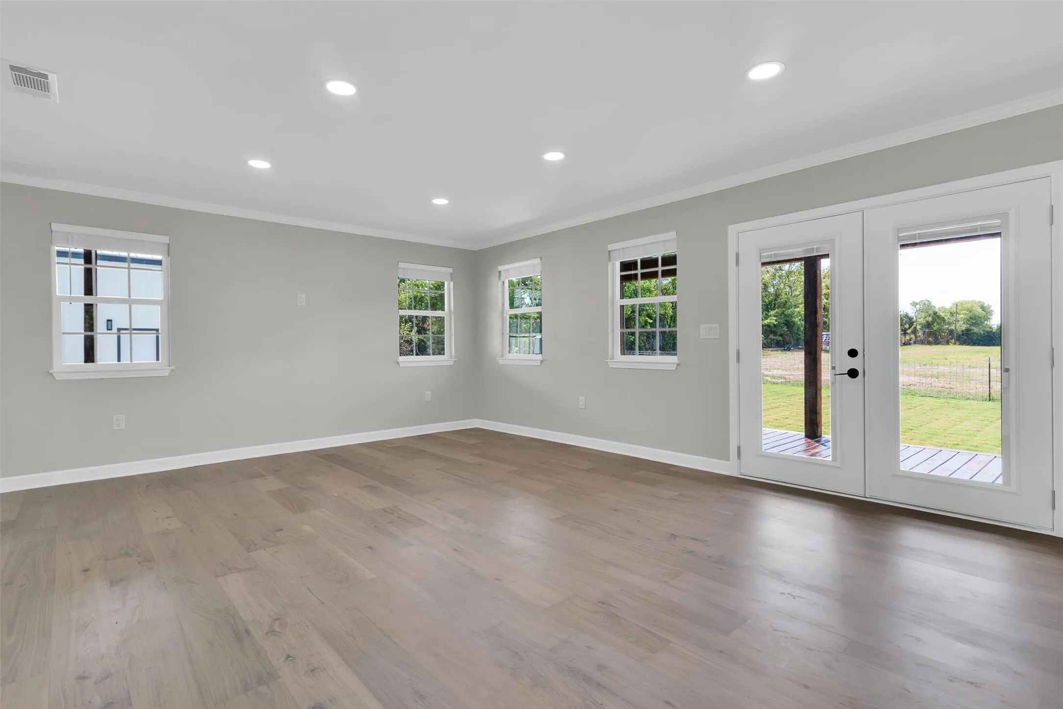 Recessed lighting, wood-finish flooring, multiple windows, French doors, and crown molding