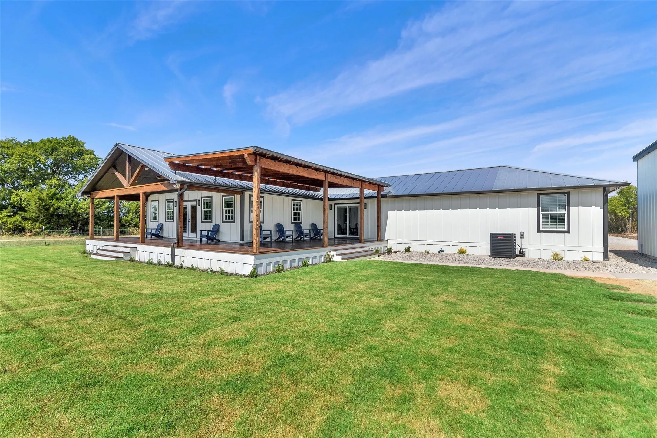 Expansive porch with a gable roof, exposed wood beams, and a metal roof