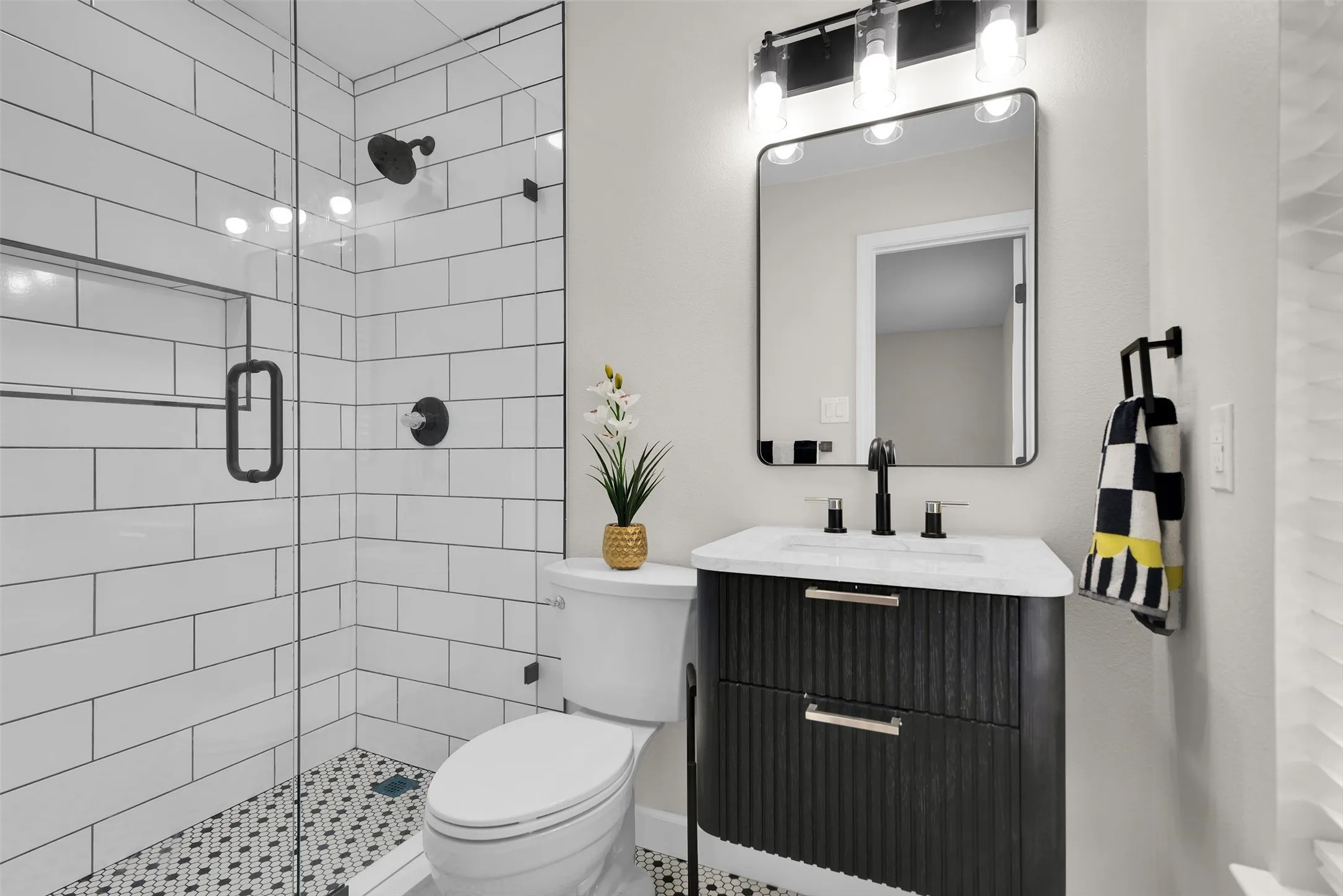 Glass-enclosed shower with white subway tile