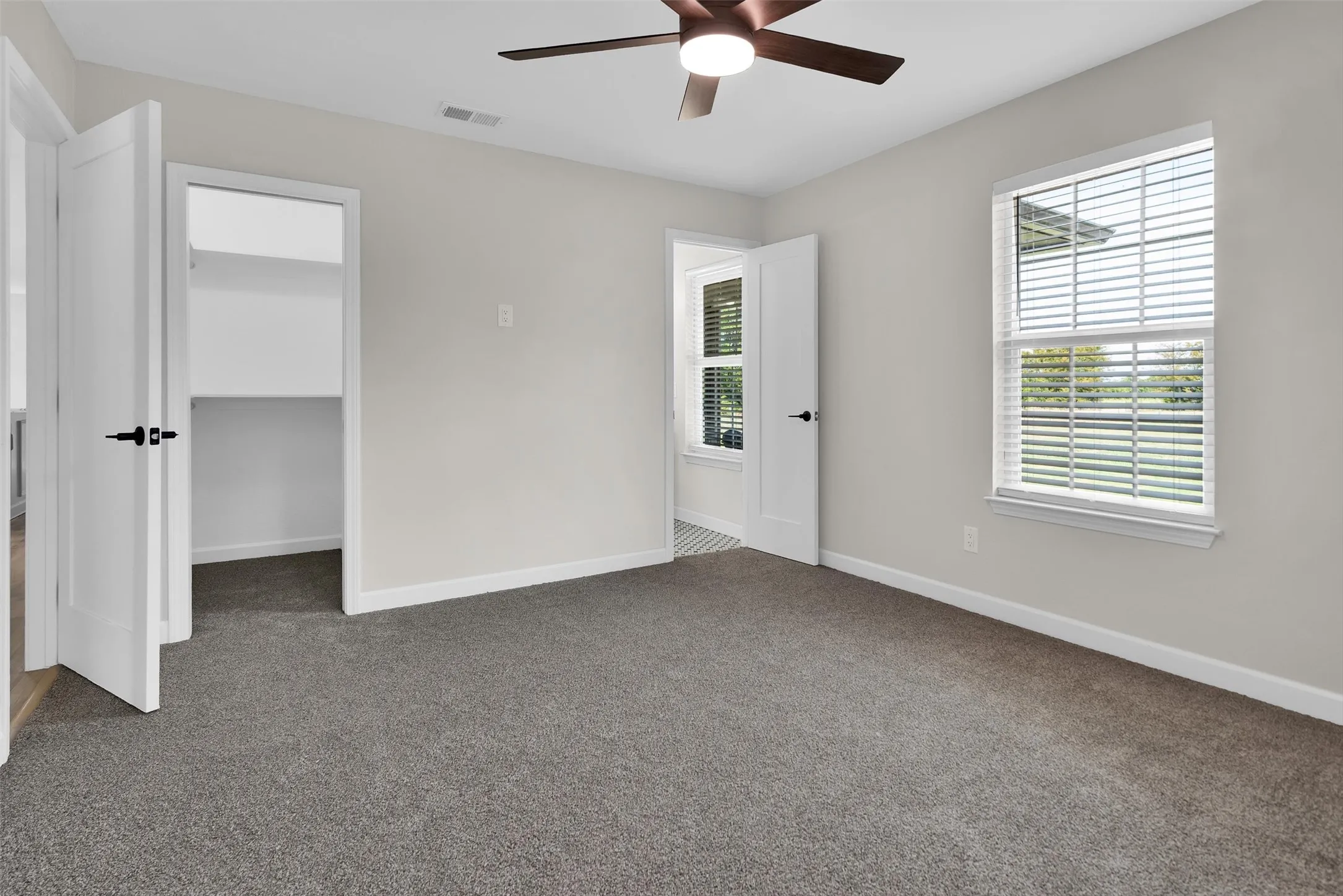 Neutral wall color, carpet flooring, ceiling fan, white trim, and a window with blinds