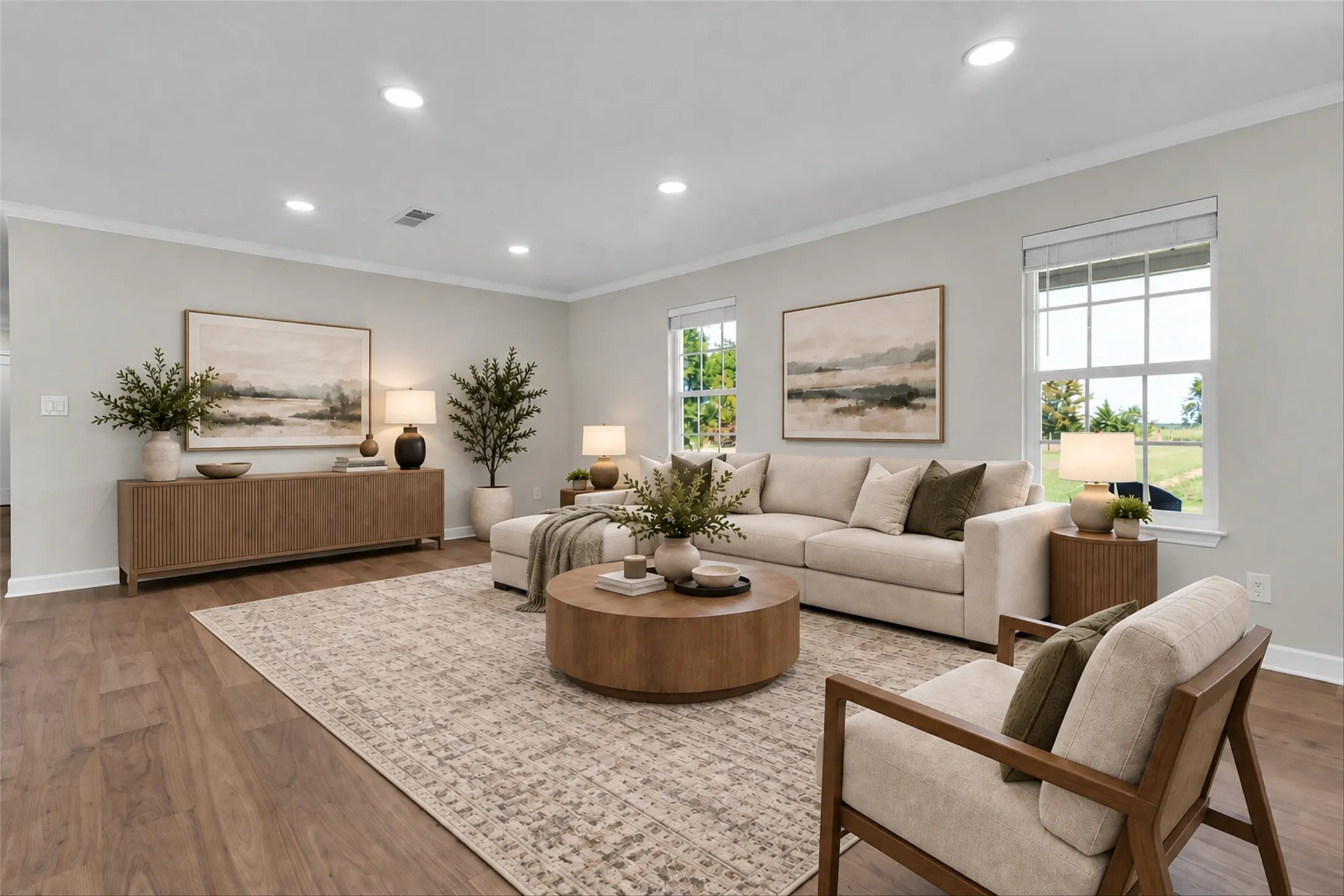 Spacious living area featuring wood-finish flooring, recessed lighting, crown molding, and multiple windows
