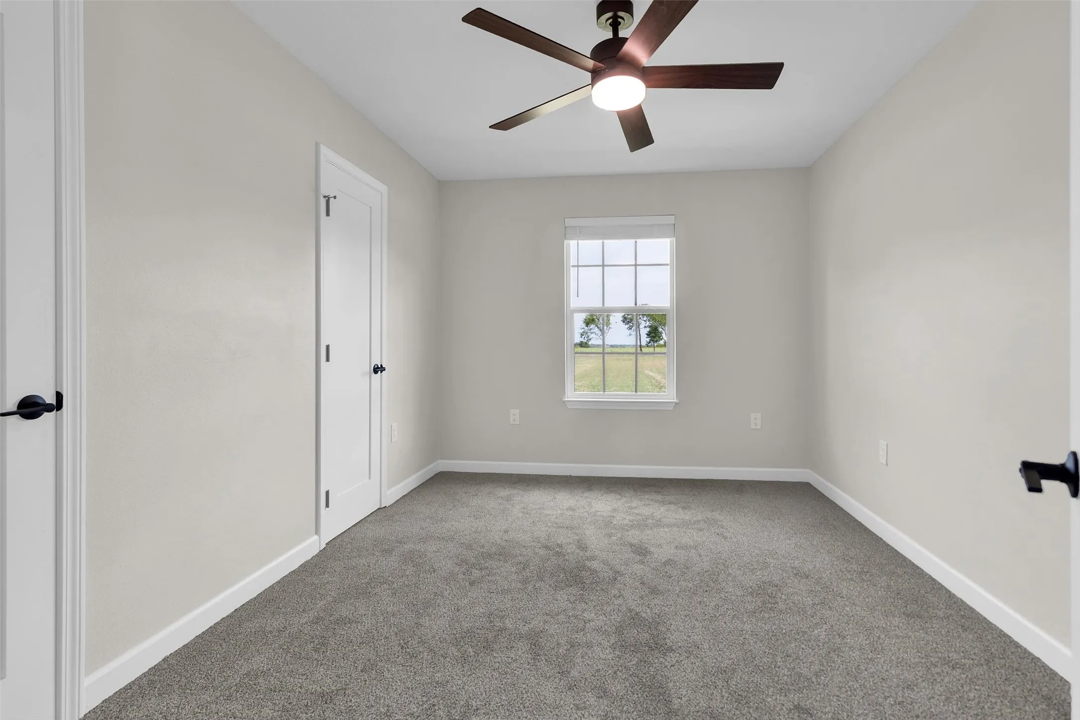 Neutral wall color, gray carpet flooring, white trim, ceiling fan with integrated lighting, and a window with horizontal blinds