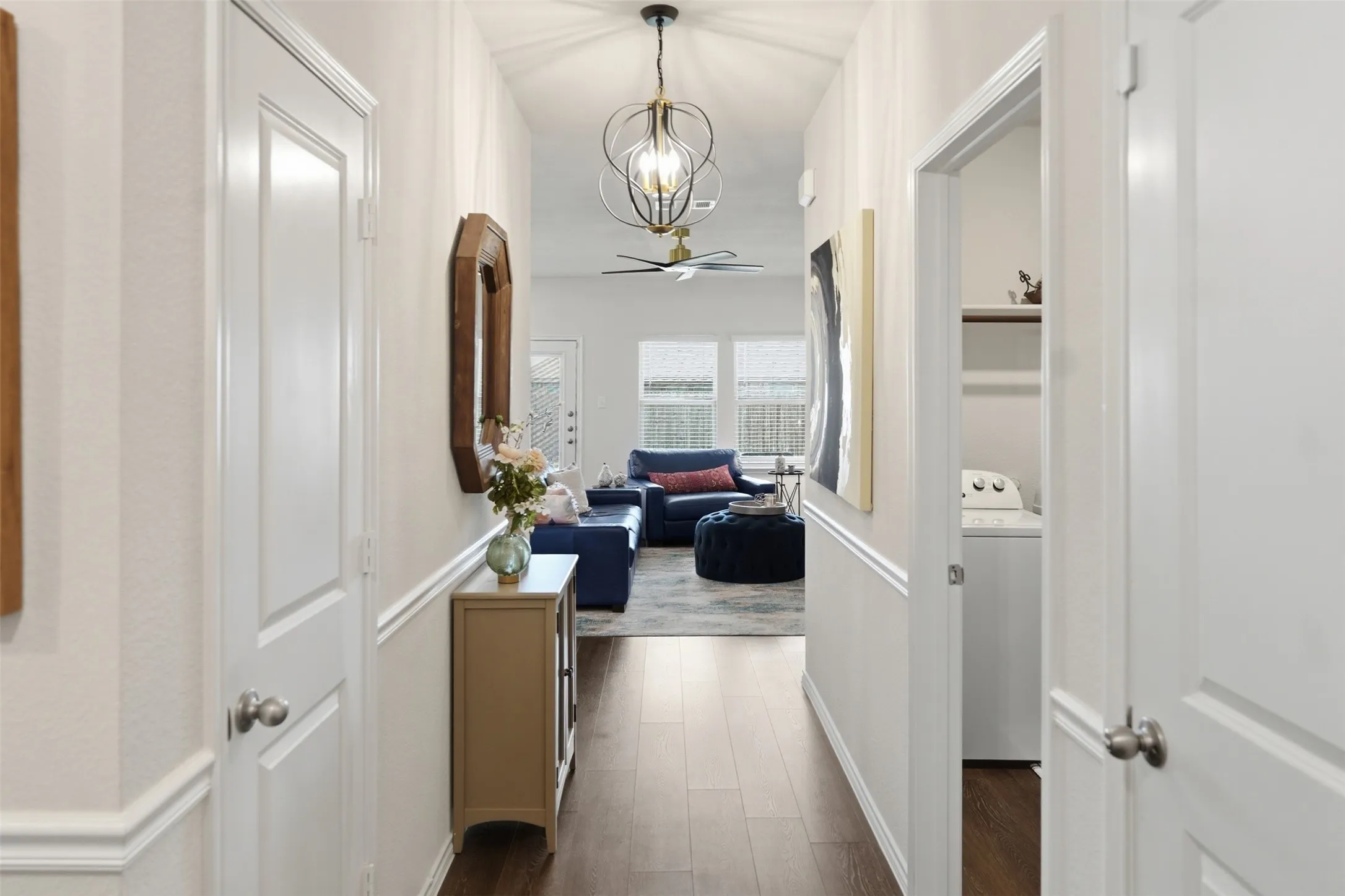 Foyer - Hallway featuring wood-finish flooring, white paneled doors, and a decorative pendant light fixture