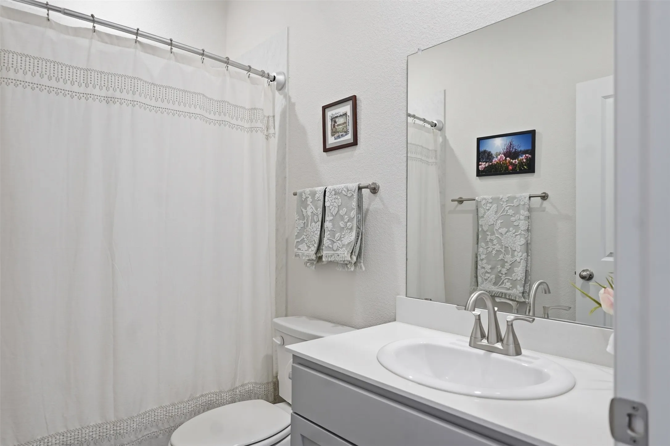 Bathroom 2 - Vanity with an integrated oval sink, brushed nickel faucet, and a large wall-mounted mirror