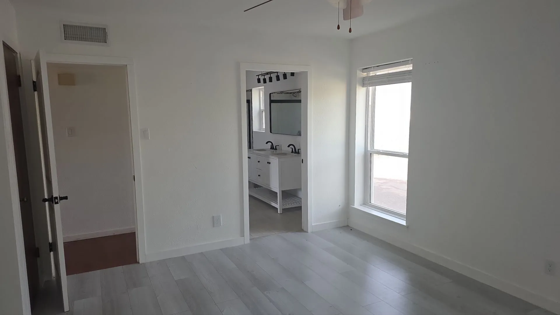 Light wood-finish flooring with white walls