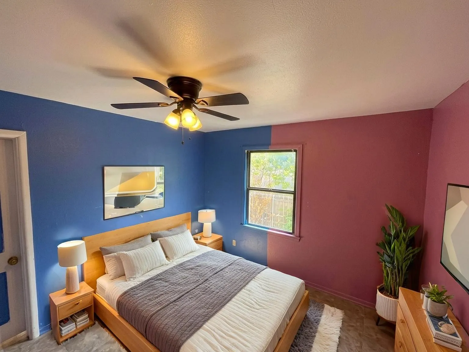 Virtually staged
Bedroom featuring a ceiling fan with integrated lighting, a window providing natural illumination, and wood-finish flooring