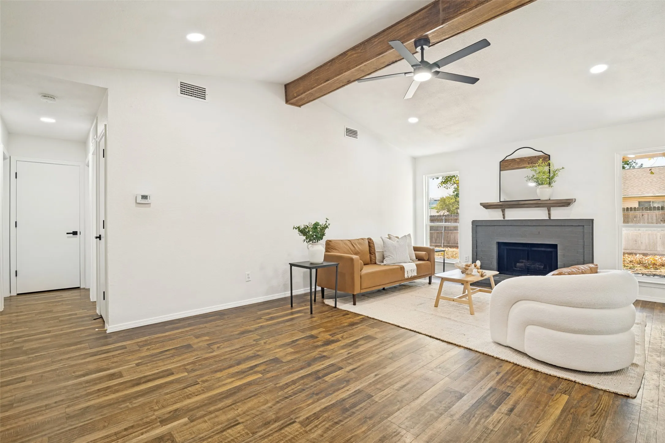 Vaulted ceiling with wood beams, recessed lighting, wood-finish flooring, fireplace with mantel, and a ceiling fan