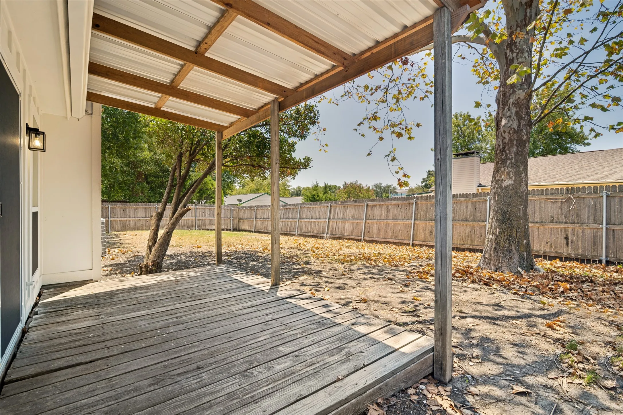 Covered wood deck with corrugated metal roof and exposed wood framing