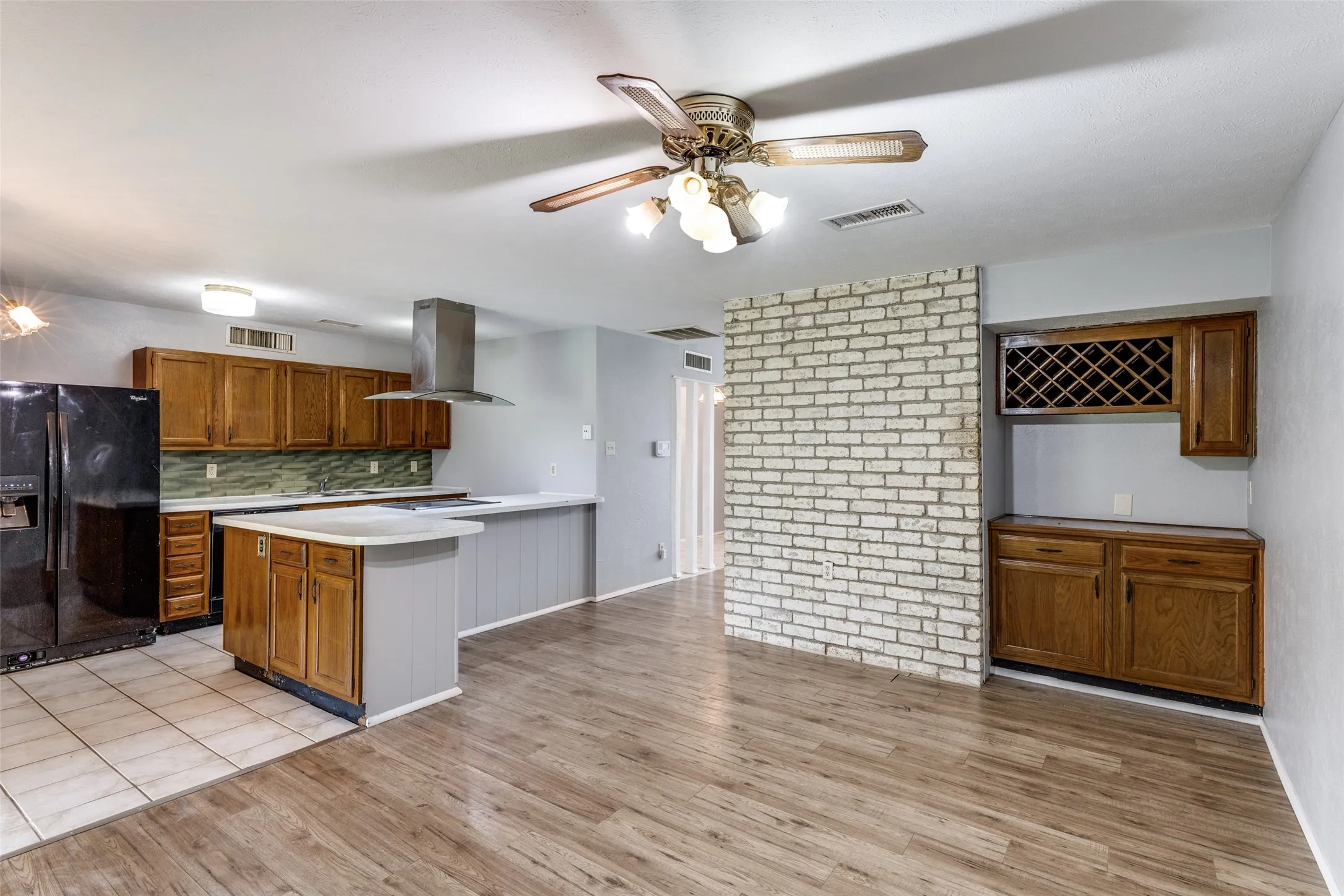 Kitchen and dining room with wood-finish flooring and a dry bar with a lattice-style wine rack