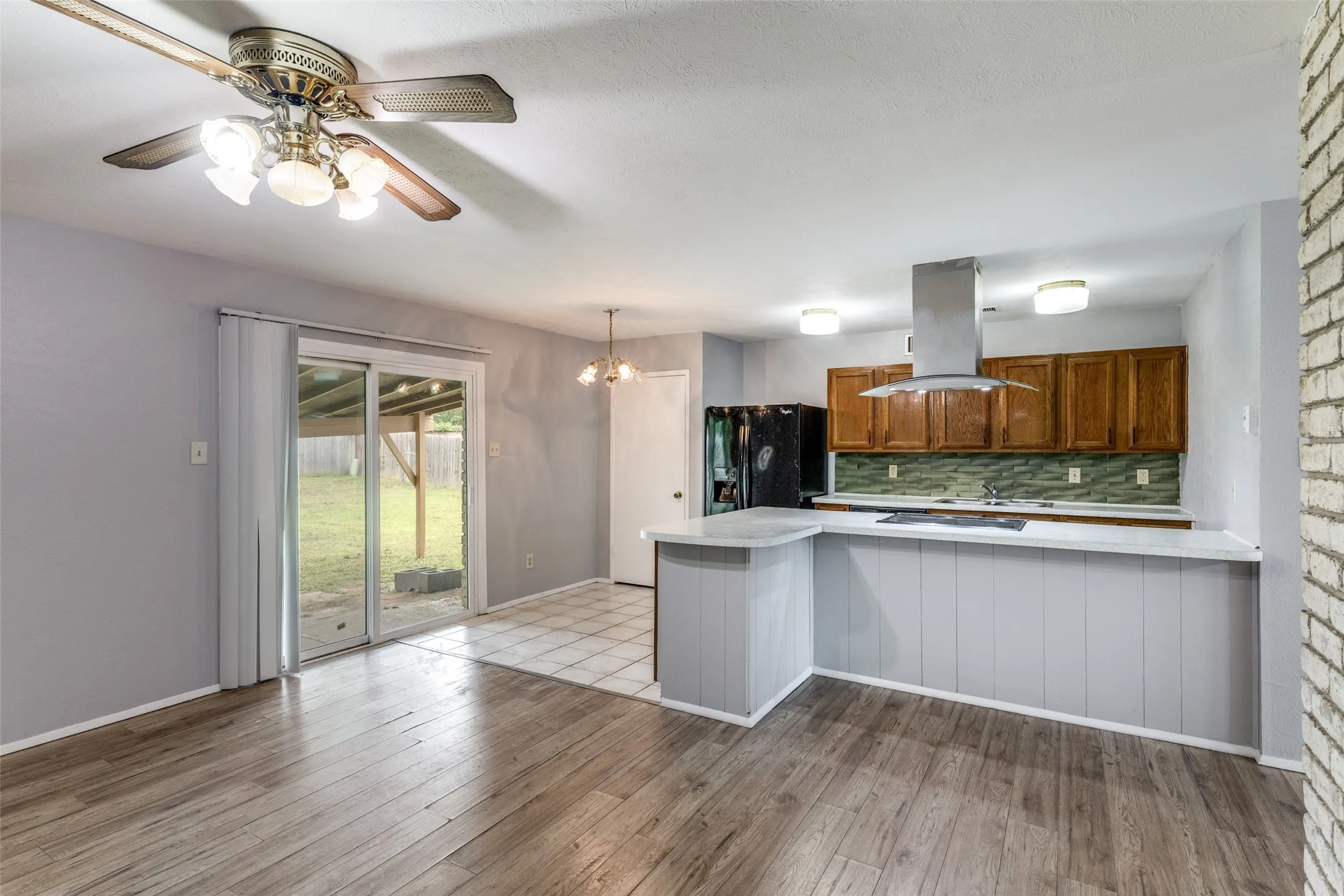 Open-concept dining and kitchen area with sliding glass door leading to the backyard