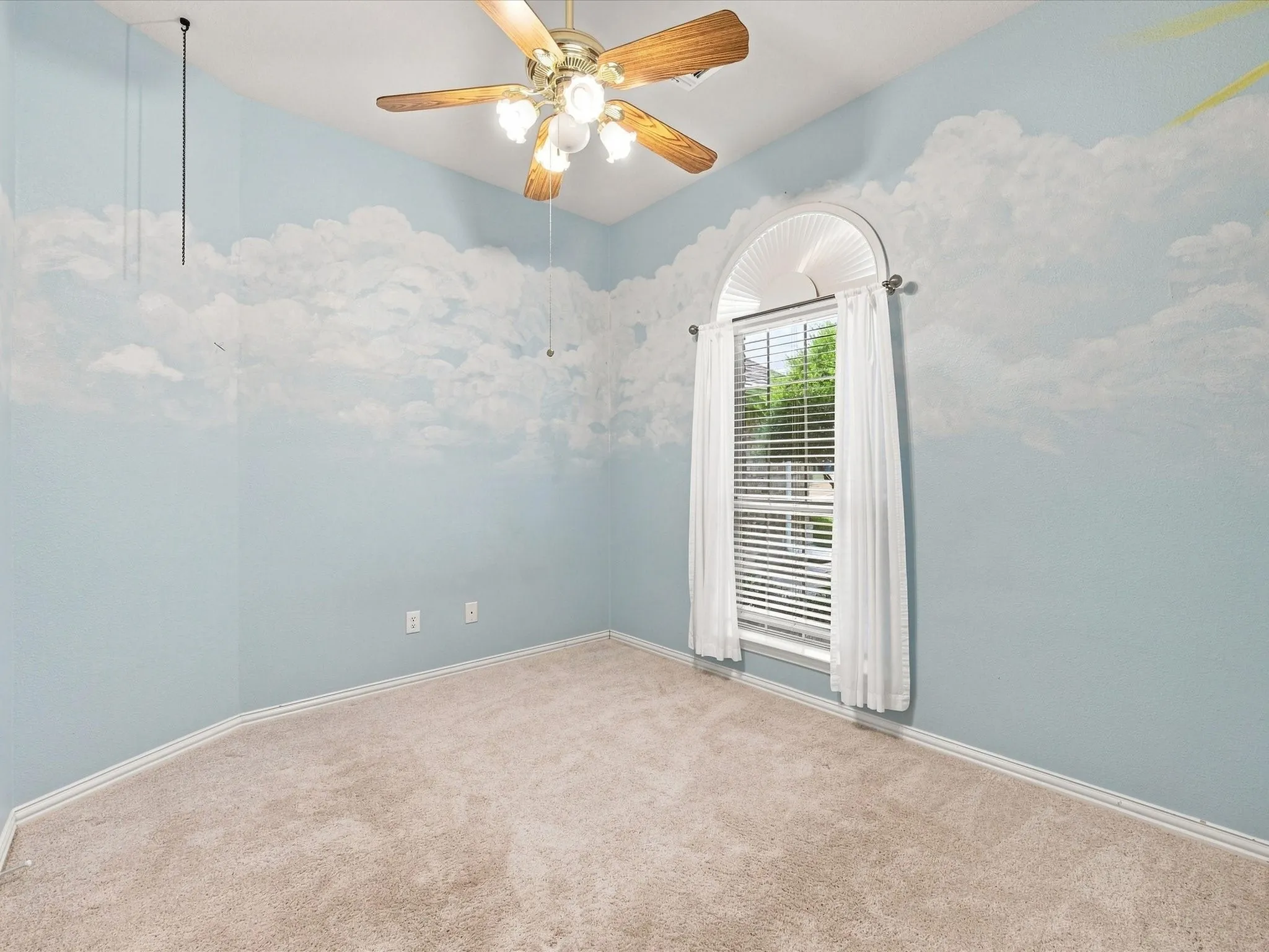 Arched window with blinds, wood-finish ceiling fan, and carpeted flooring