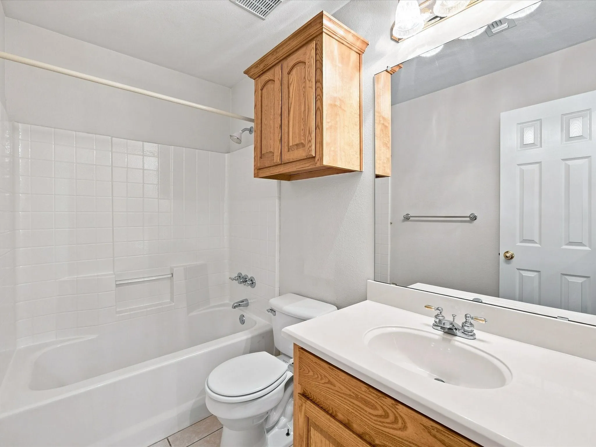 White tile-surround bathtub with integrated soap dish