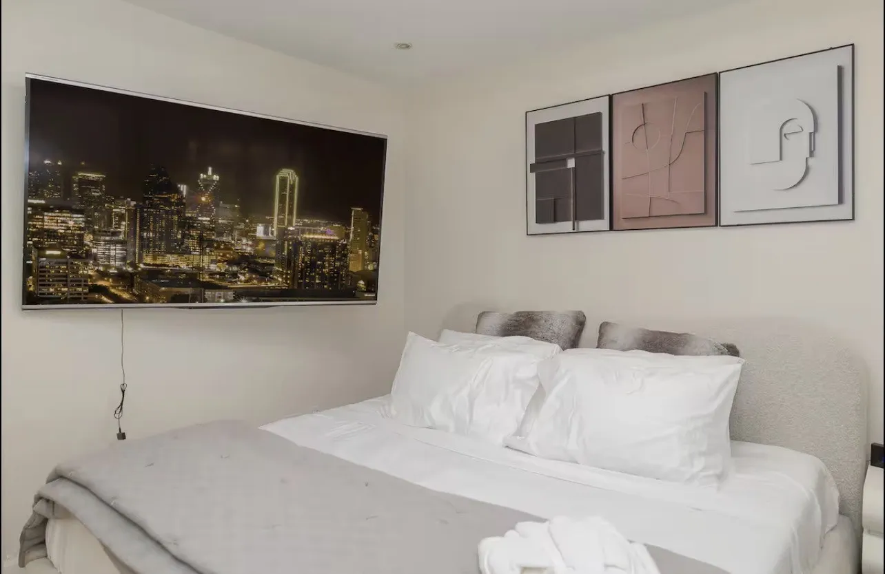 Recessed lighting, wall-mounted television, and upholstered headboard