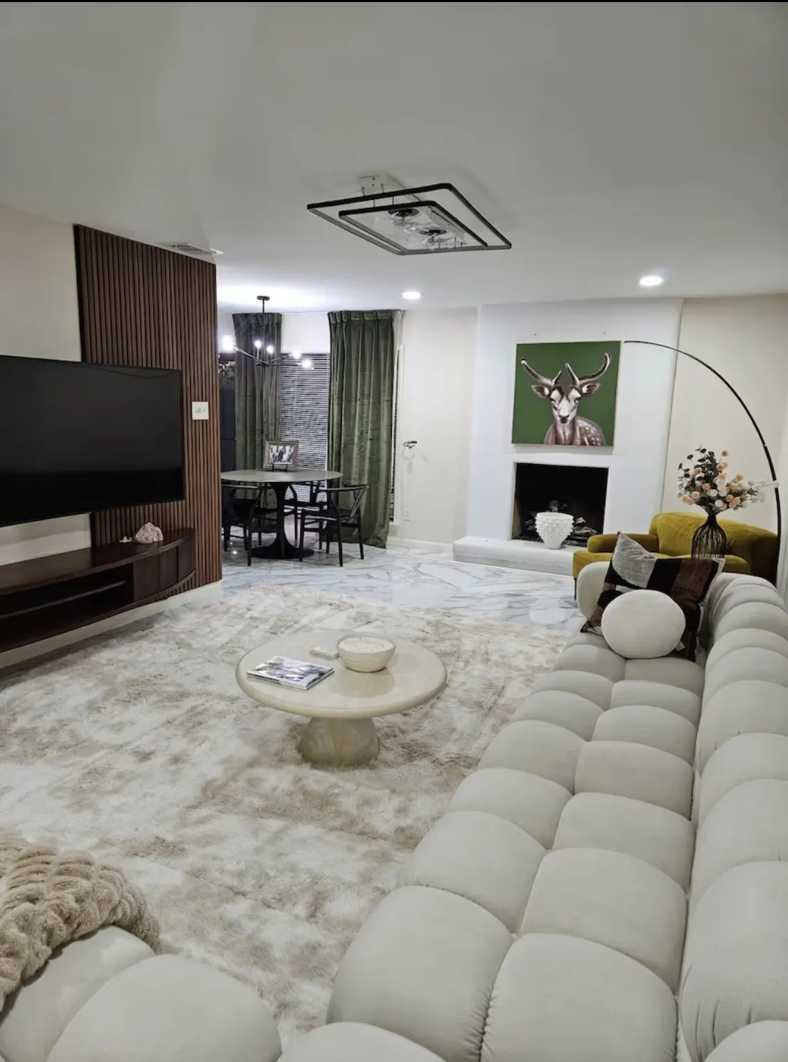 Recessed lighting, a decorative wall panel, a built-in media console, a modern fireplace, and a rectangular ceiling light fixture