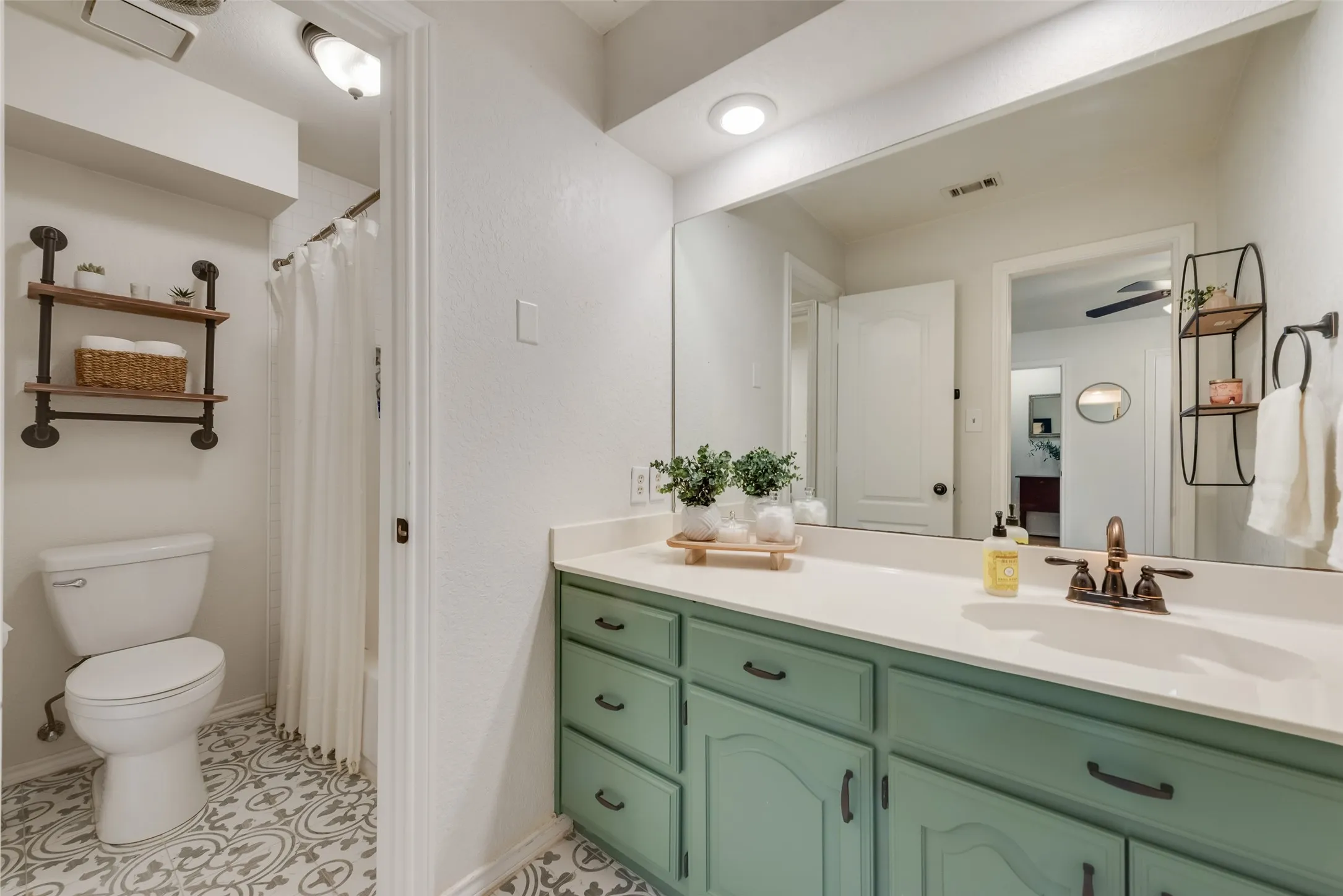 Vanity with a sink is connected to bedroom 3. Peek the pretty tiled floors!