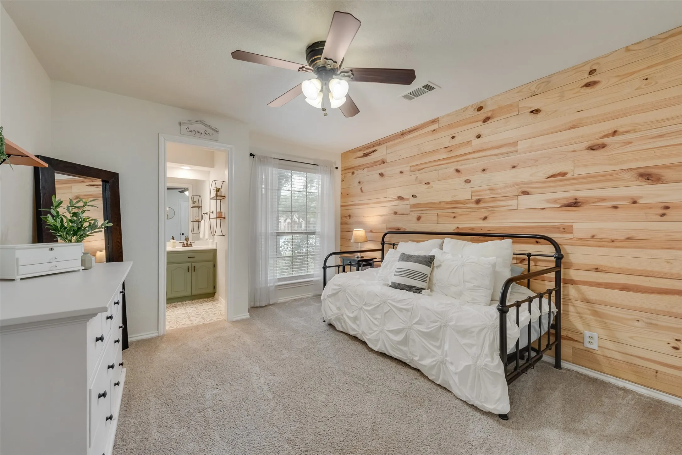 Secondary bedroom has lovely paneled wall and a private vanity with a sink.
