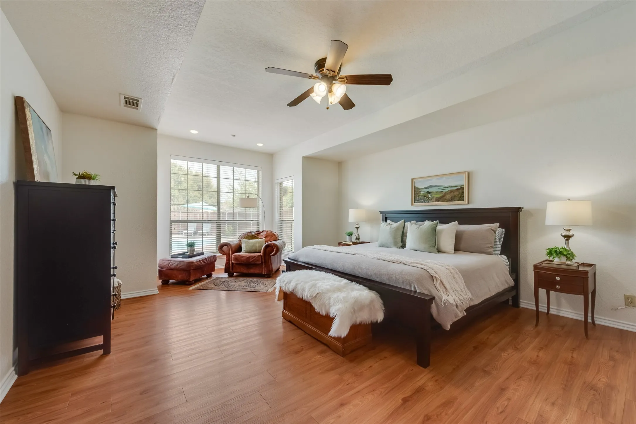 Tray ceiling adds height and interest to the primary bedroom which also has a reading nook