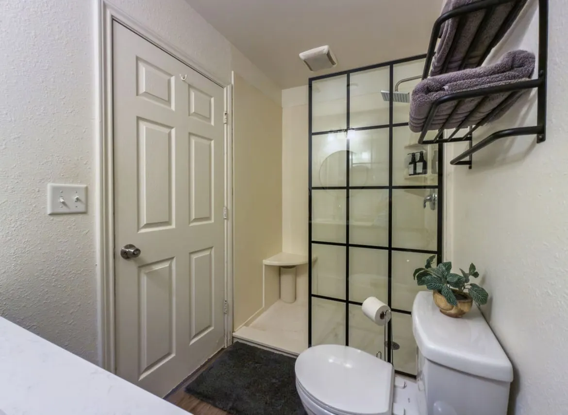 Modern shower enclosure with black grid-patterned glass and rainfall showerhead
