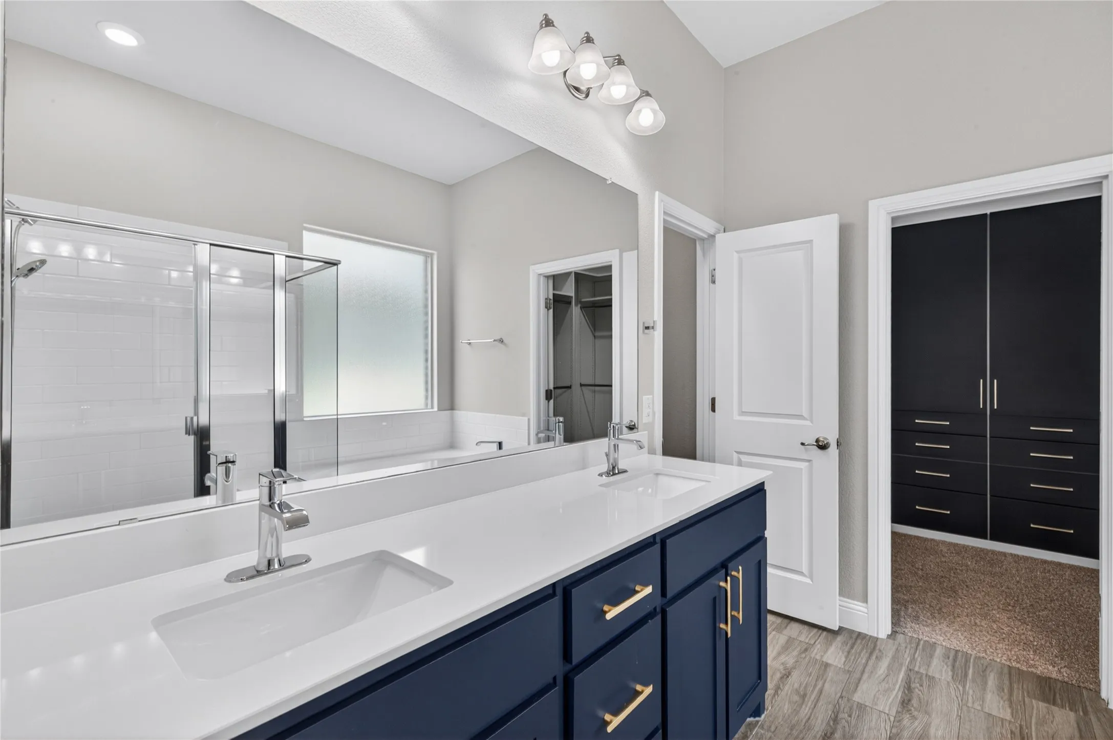 Dual vanity with white countertop, chrome fixtures, and blue cabinetry