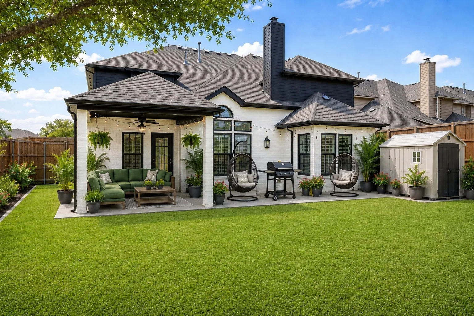 Manicured lawn, covered patio, white brick exterior, bay window, and storage shed