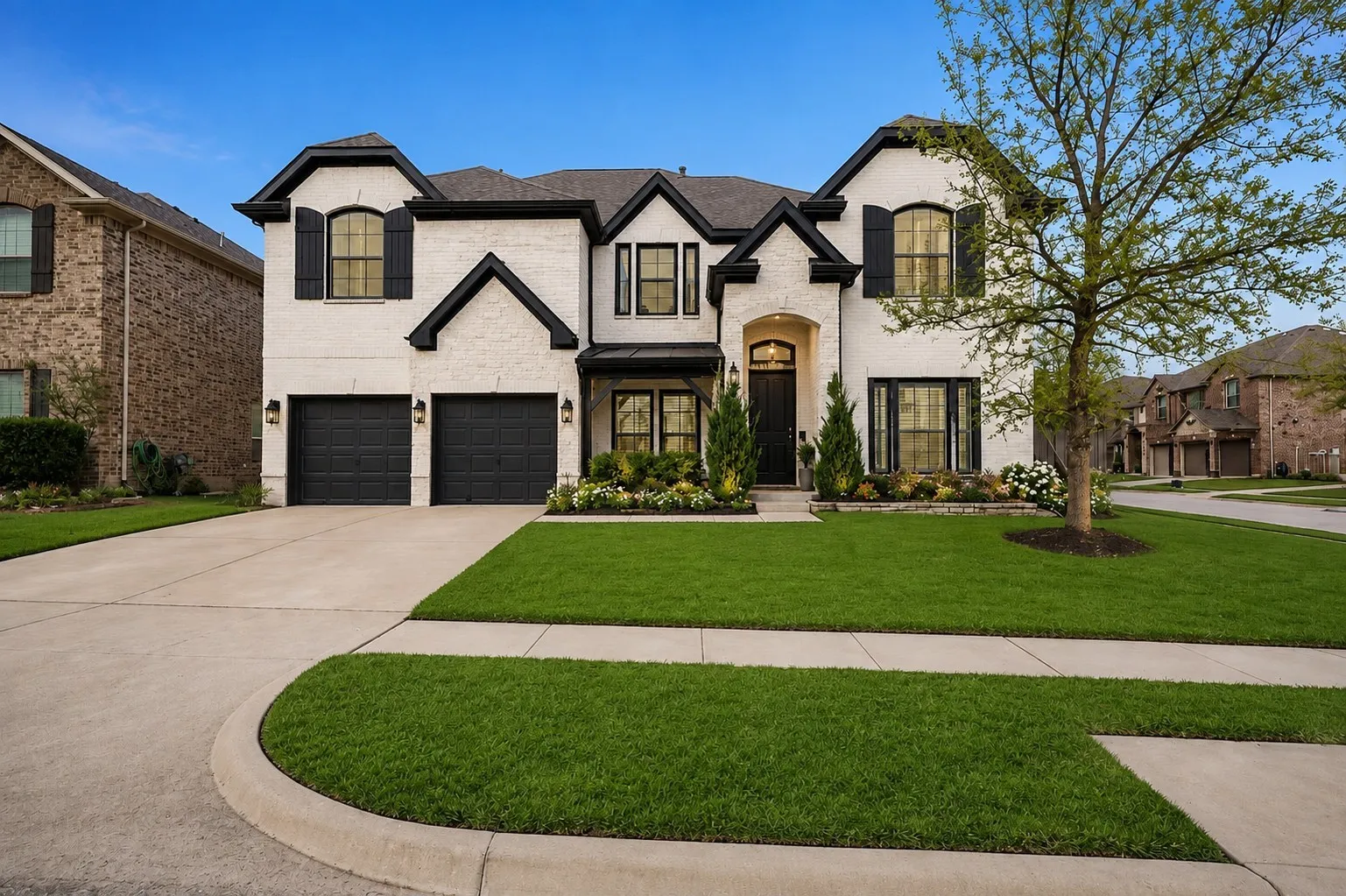 Two-story home with white brick exterior and dark trim accents
