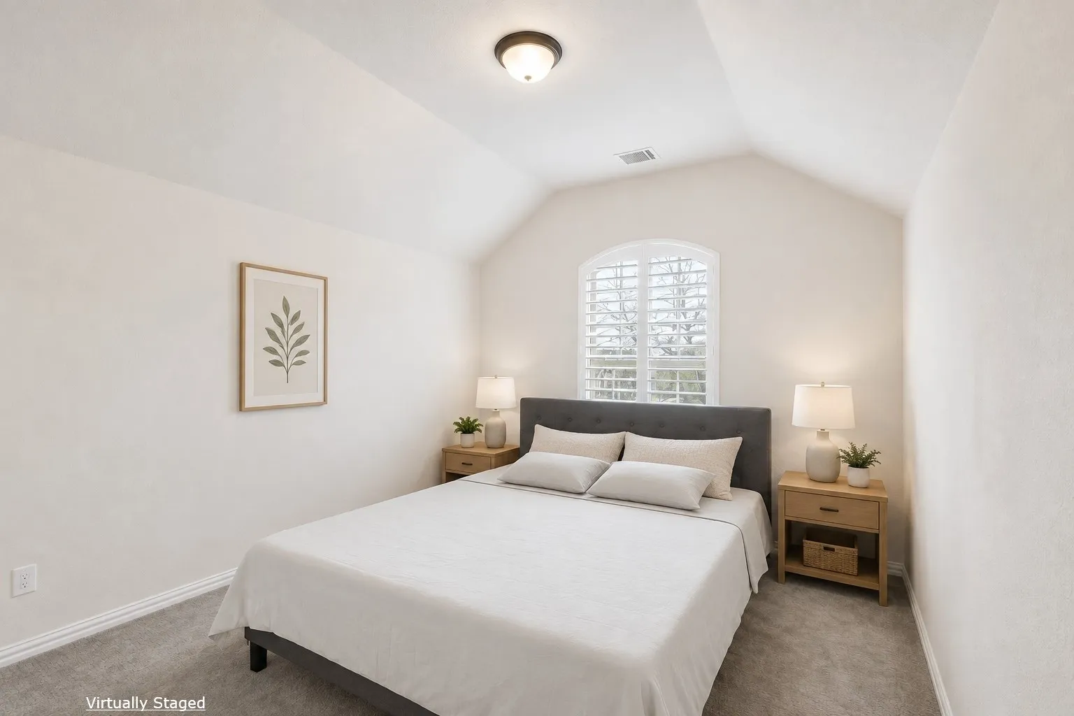 Vaulted ceiling with a flush-mount light fixture, arched window with plantation shutters, light gray wall color, and gray carpet flooring
