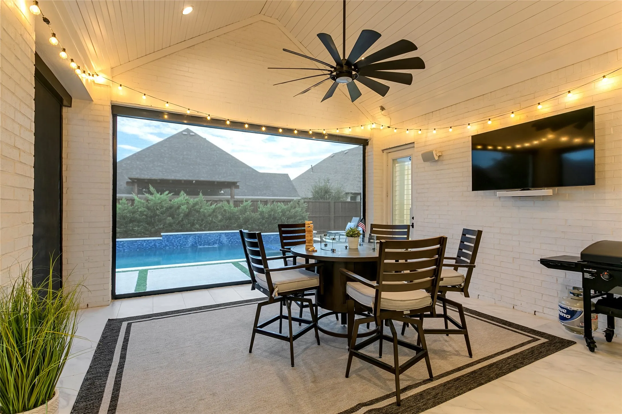 The patio’s electric screens create an enclosed feel without losing the pool view.