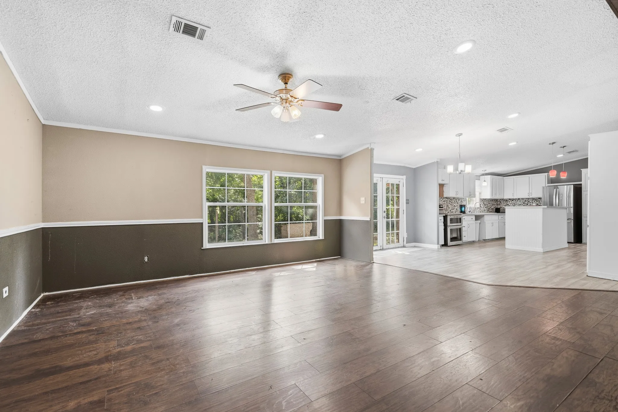 Wood-finish flooring, recessed lighting, and a ceiling fan in the living area