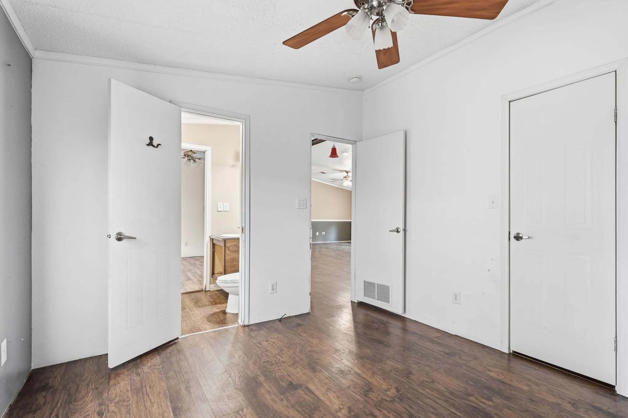 Wood-finish flooring, white walls, and a ceiling fan with integrated lighting