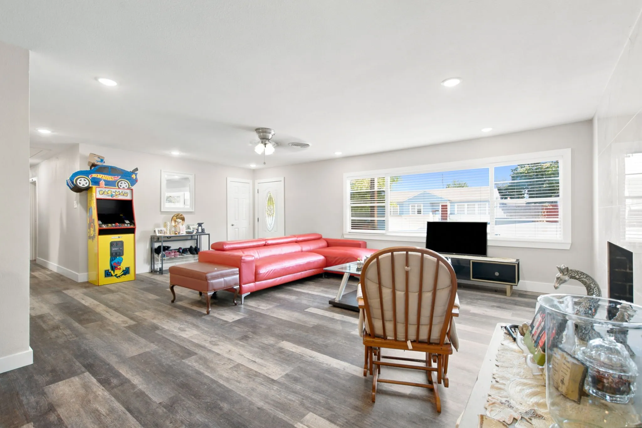 Recessed lighting, wood-finish flooring, ceiling fan, wide window with blinds, and a white paneled door