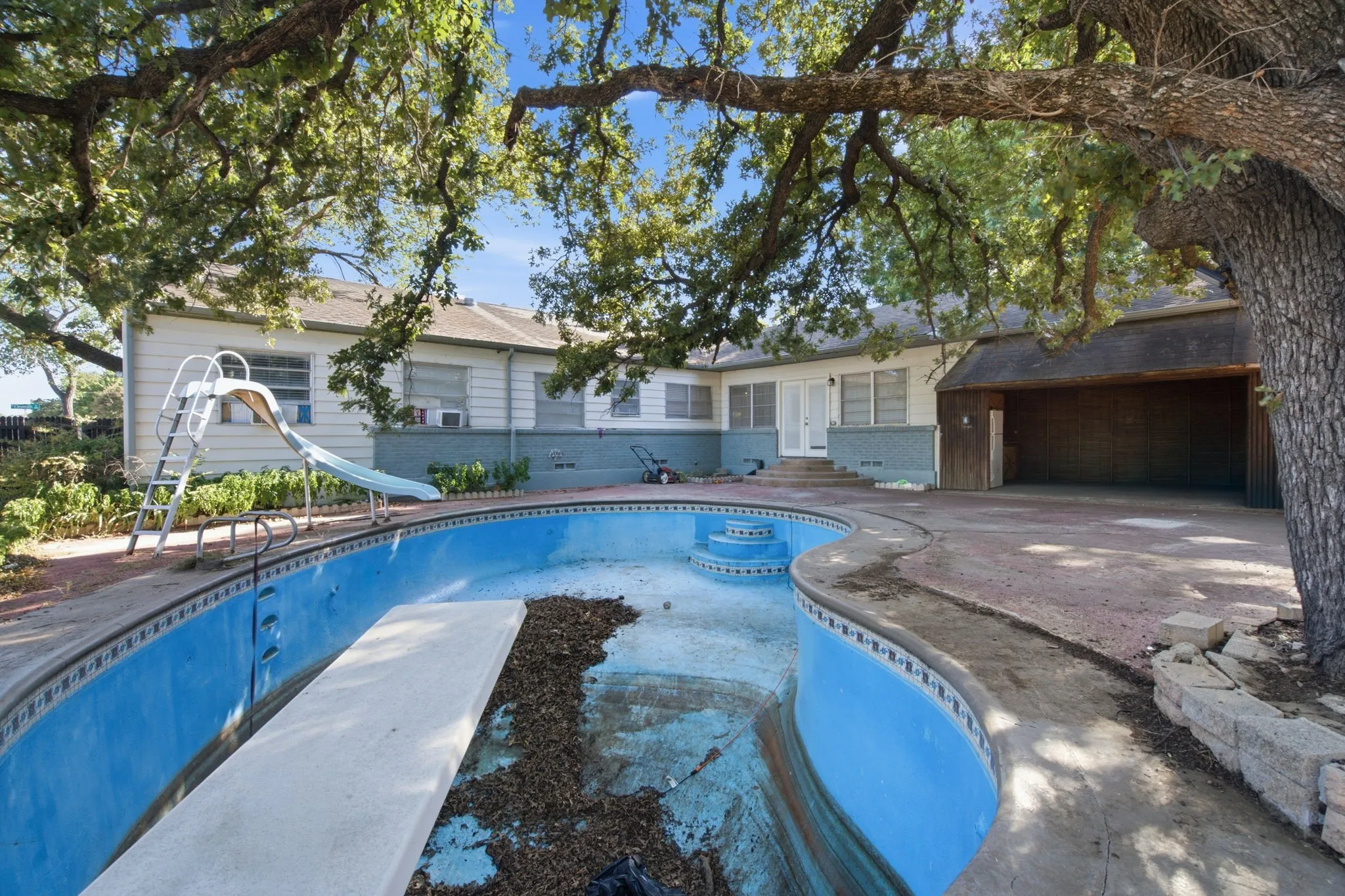 In-ground swimming pool with diving board and slide