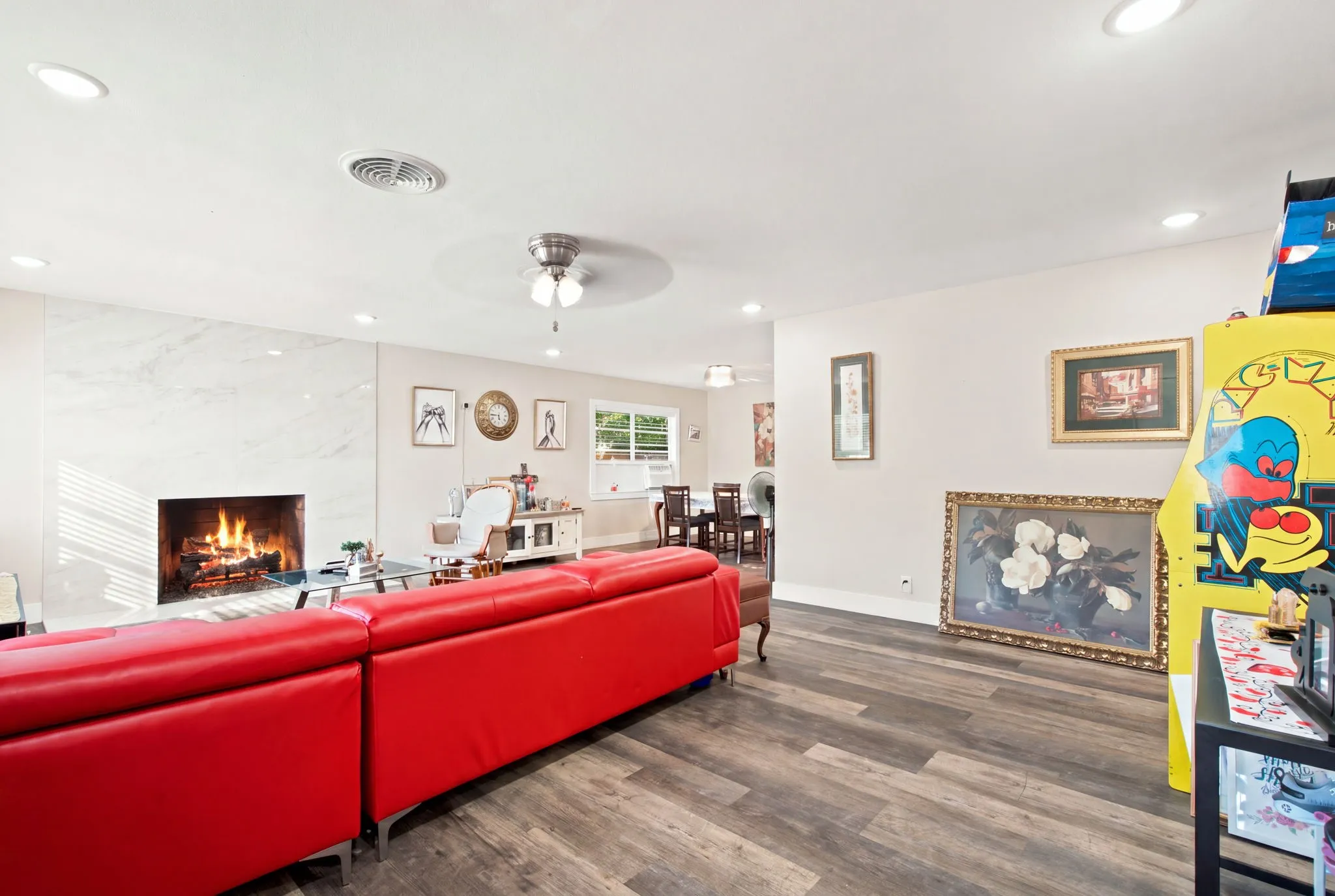 Living area featuring wood-finish flooring, a white marble-look fireplace, recessed lighting, and a ceiling fan